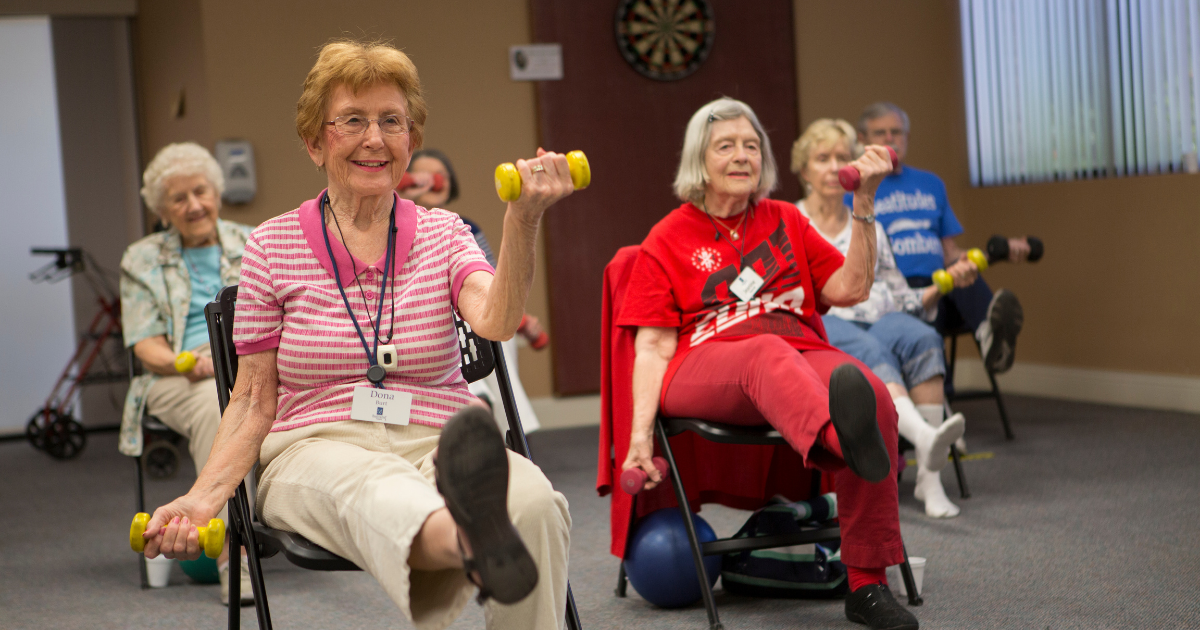 Women smiling while lifting weights.