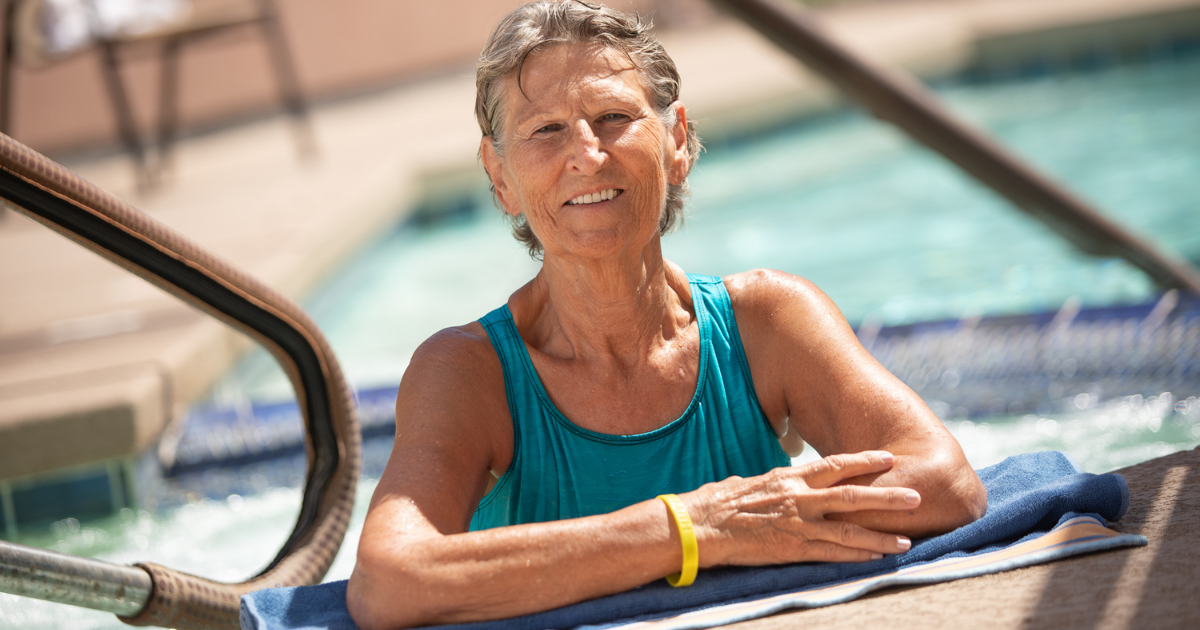 Woman embraces a heathy aging routine while smiling in the pool.